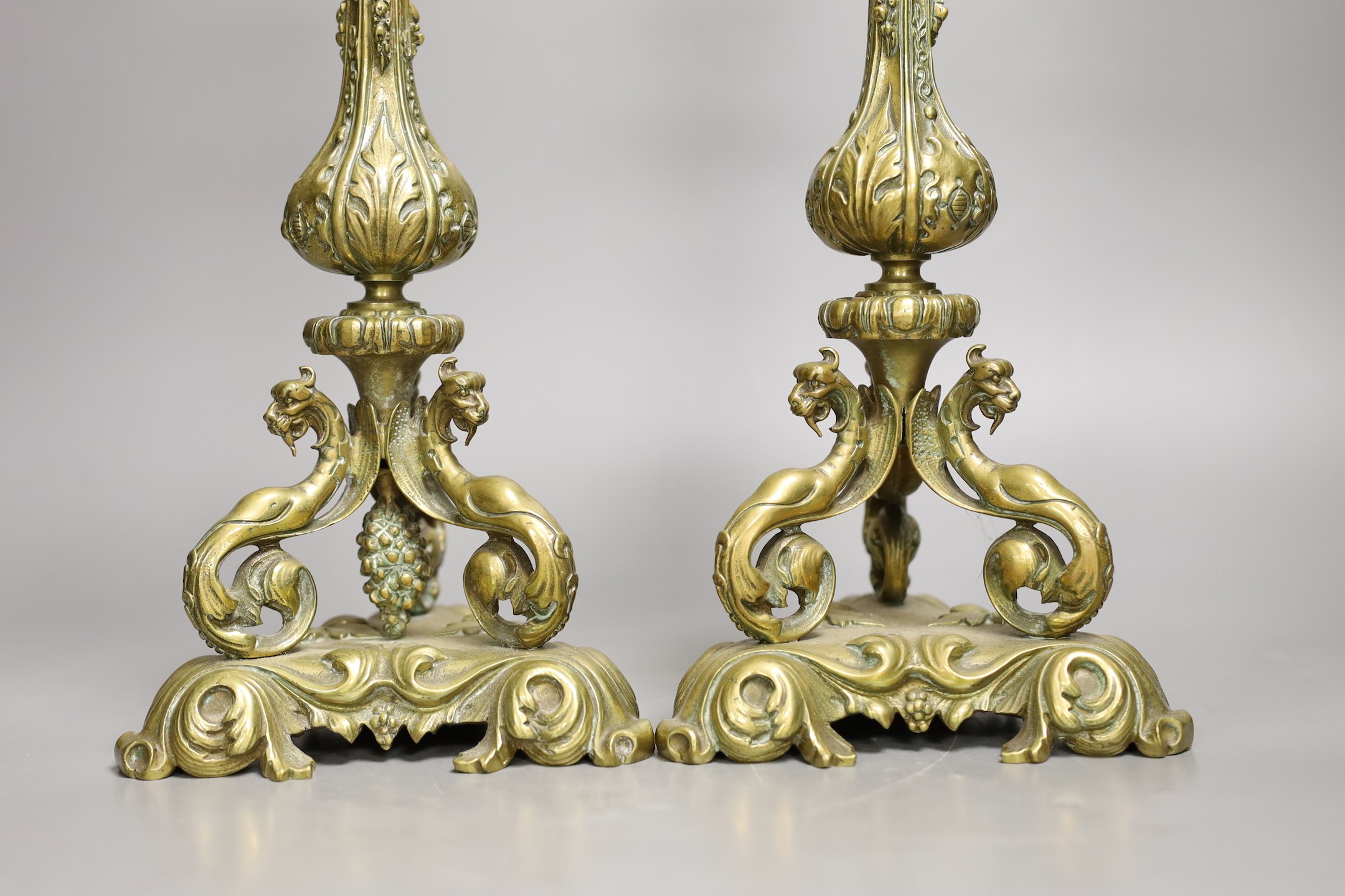 A pair of 19th century ornate brass candlesticks, 31cms high